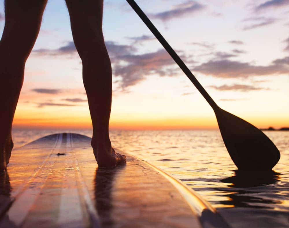 paddleboarding with sunset view on the water