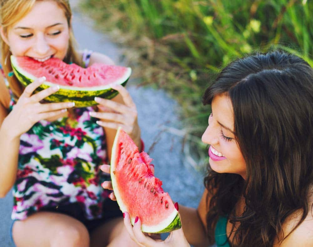 two people eating watermelon