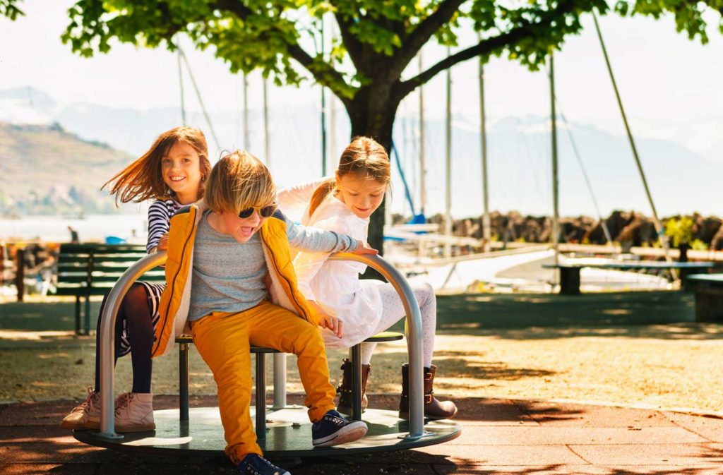 three kids playing on a playground