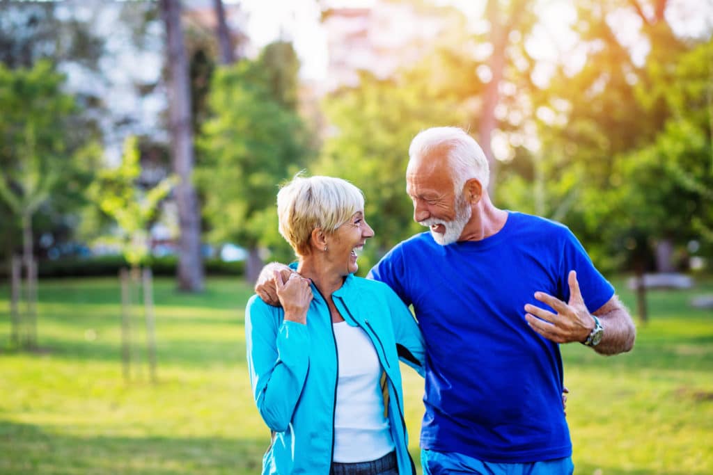 A happy senior couple taking a walk in an outdoor park