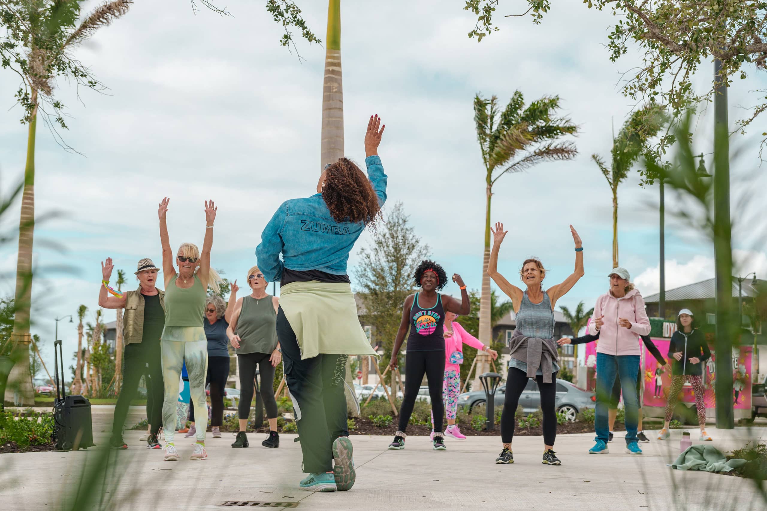 People with their arms raised in the air during Zumba class in Downtown Wellen