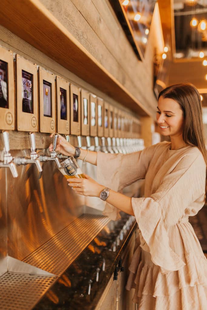 Person pouring beer out of self-service beer tap
