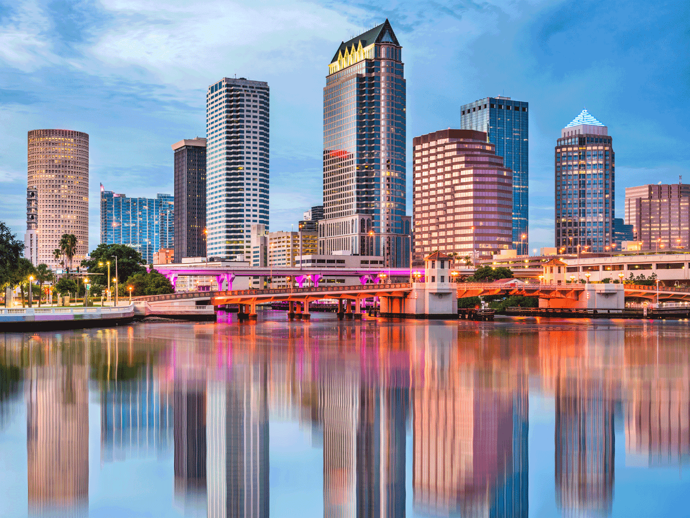 Downtown Tampa skyline at sunset with colorful reflections on the Hillsborough River.