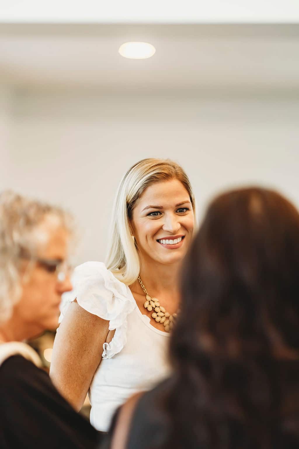 Guest smiling and chatting during a bright indoor celebration, captured in a candid moment.