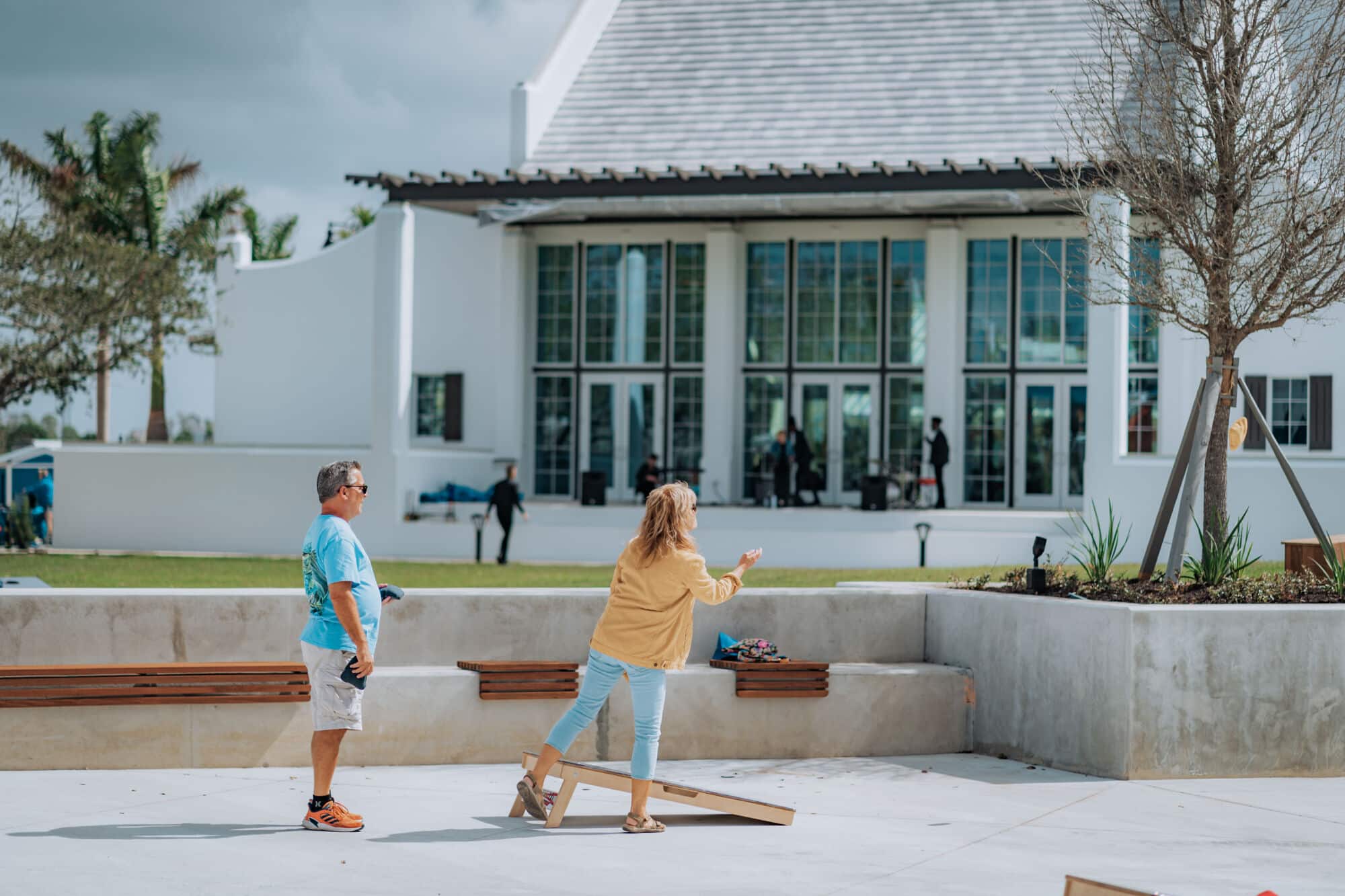 A couple playing a game of cornhole in a community park at Wellen Park