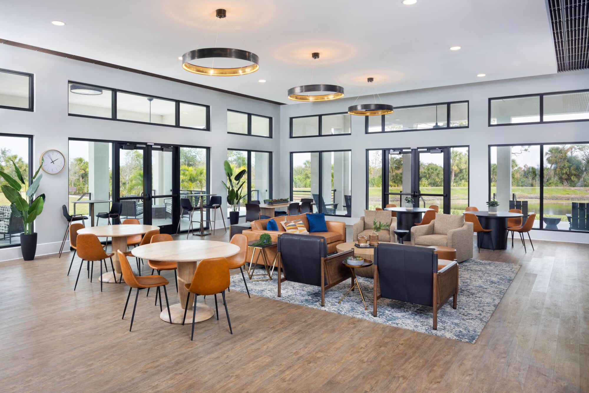 A lounge with dining tables and high tables at the Sunstone Lakeside residential community at Wellen Park