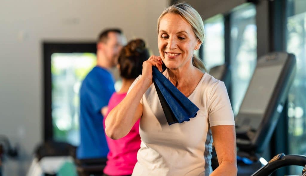 A woman wiping herself down in a fitness center at the Esplanade community at Wellen Park