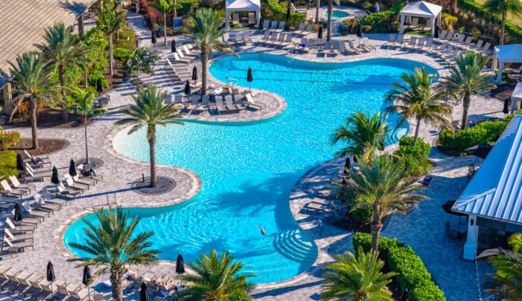 A resort style pool with several lounging chairs with covers at the Esplanade community at Wellen Park