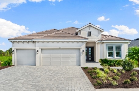 A single family home with a brick driveway and garden out front at the Esplanade community at Wellen Park