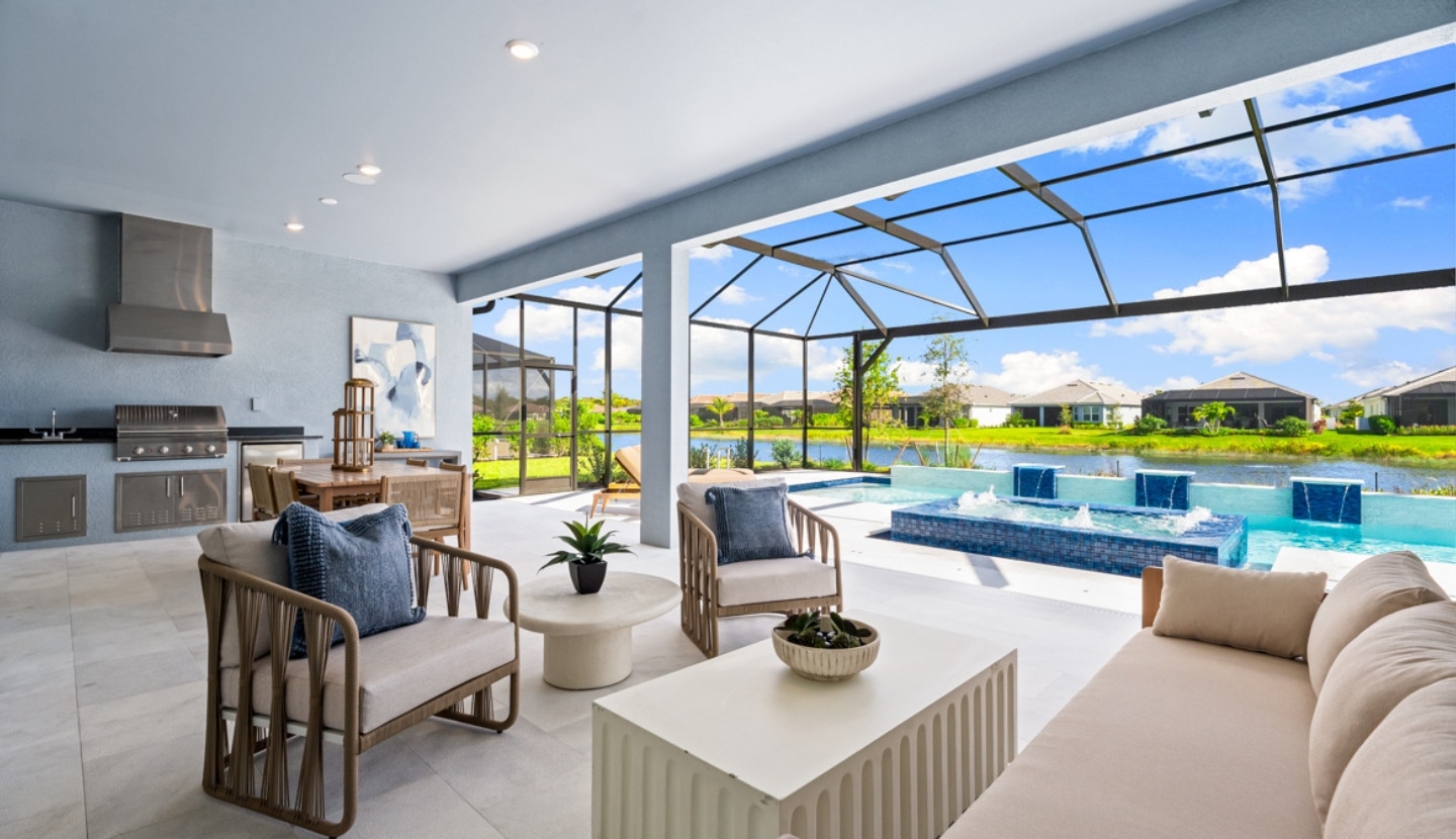 A spacious back patio with a lounge, grilling station, a pool featuring fountains and a gazebo for covering at the Esplanade community at Wellen Park