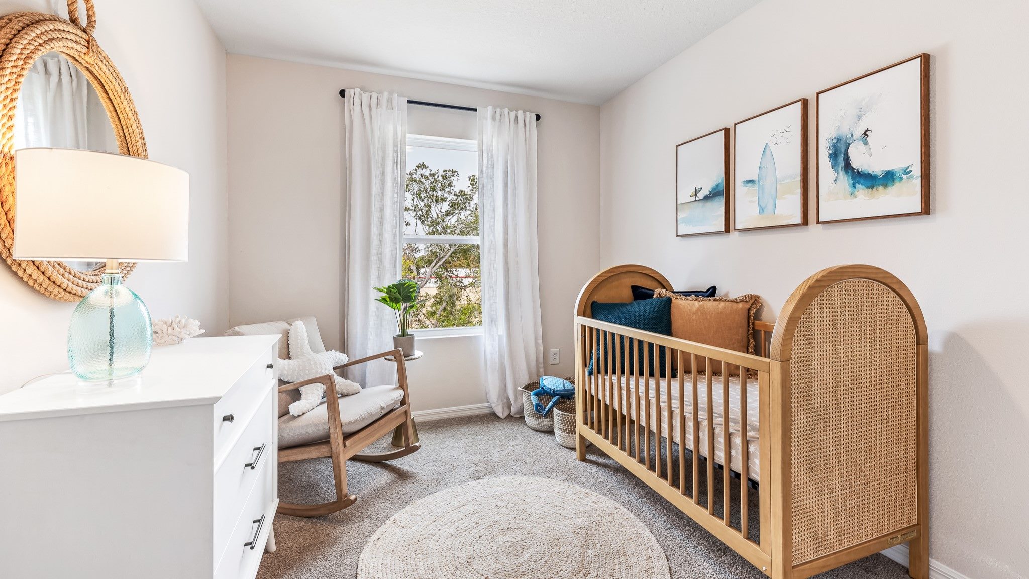 Cozy nursery with a wood crib, rocking chair, soft neutral tones, and coastal-inspired decor, filled with natural light.
