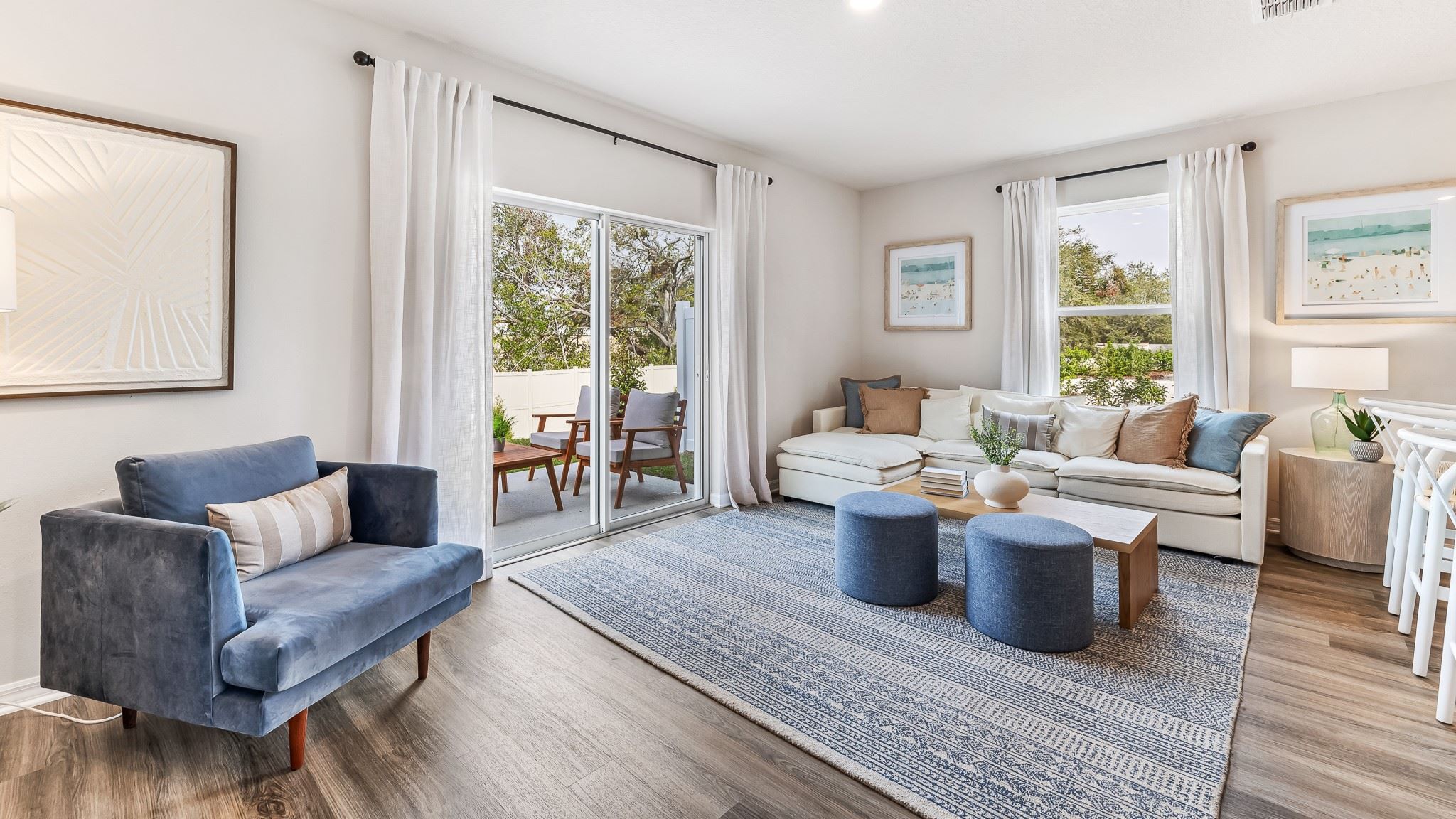 Sun-filled living room featuring a cozy sectional, stylish accent chair, and sliding glass doors that open to a private outdoor patio, creating a seamless indoor-outdoor flow.